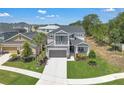 Aerial view of a gray two-story home surrounded by lush landscaping, a two-car garage, and neighborhood views at 2845 High Pointe St, Clermont, FL 34711