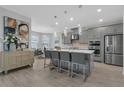 Modern kitchen with gray cabinets, a large island, stainless steel appliances, and an adjacent dining area at 2845 High Pointe St, Clermont, FL 34711