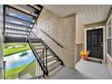 Condo entrance with black door and stairs overlooking scenic canal, offering a welcoming, waterfront arrival at 4740 Walden Cir # 28, Orlando, FL 32811