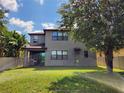 A spacious backyard featuring lush green grass, trees, and a covered patio area at 5107 Appenine W Loop, St Cloud, FL 34771