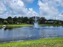 Picturesque pond with a fountain, surrounded by lush greenery and a clear blue sky at 5107 Appenine W Loop, St Cloud, FL 34771