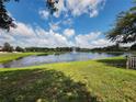 Scenic view of a tranquil pond with a fountain and green grassy shoreline at 5107 Appenine W Loop, St Cloud, FL 34771