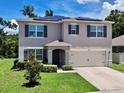 Charming two-story home featuring a well-manicured lawn and a convenient two-car garage at 6780 Coral Berry Dr, Mount Dora, FL 32757