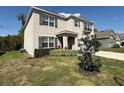 Well-maintained two-story home with gray exterior and neatly landscaped front yard at 6780 Coral Berry Dr, Mount Dora, FL 32757