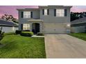 Charming two-story home featuring a well-manicured lawn and a convenient two-car garage at 6780 Coral Berry Dr, Mount Dora, FL 32757