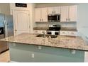 Modern kitchen features granite countertops, stainless steel appliances, and ample cabinet space at 6780 Coral Berry Dr, Mount Dora, FL 32757
