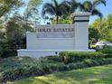 Holly Estates entrance sign surrounded by lush landscaping and mature palm trees at 6780 Coral Berry Dr, Mount Dora, FL 32757