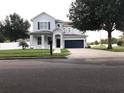 Lovely home with a well-kept lawn, dark shutters, and an attached two-car garage at 7561 Colbury Ave, Windermere, FL 34786