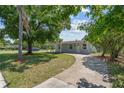 A charming single-story home with a well-manicured lawn and a winding driveway leading to the house at 7701 Cassino Ave, Orlando, FL 32819