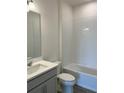 Bathroom featuring a combination tub and shower, a vanity with sink and gray cabinet at 7980 Syracuse Dr, Clermont, FL 34714