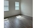 Bright bedroom with two windows and stylish gray wood-look tile flooring at 7980 Syracuse Dr, Clermont, FL 34714