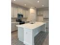 New kitchen featuring white cabinets, stainless appliances, a large island, and tiled backsplash at 7980 Syracuse Dr, Clermont, FL 34714
