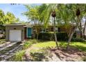 Charming home featuring a manicured lawn, palm trees, and a bright blue front door at 815 W Yale St, Orlando, FL 32804