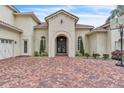 Elegant home featuring a spacious brick driveway with an arched front entry and a three-car garage at 9729 Lake Hugh Dr, Gotha, FL 34734