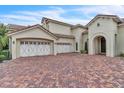 Home featuring a brick driveway and a spacious three-car garage with white doors at 9729 Lake Hugh Dr, Gotha, FL 34734