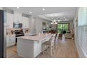 Spacious kitchen with white cabinets, stainless steel appliances, and a large center island with seating at 1392 Lombardi Ct, Kissimmee, FL 34759