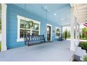Inviting covered porch featuring a hanging swing, rocking chairs and tasteful decor at 141 W Main St, Lake Helen, FL 32744
