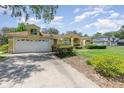 Inviting one-story home featuring an attached garage, large driveway and manicured front lawn at 1910 Palm View Dr, Apopka, FL 32712