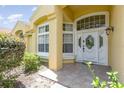 Beautiful front entry features decorative white door, sidelights, and covered porch at 1910 Palm View Dr, Apopka, FL 32712