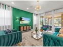 Bright living room featuring stylish furnishings, a vibrant accent wall, and sliding glass doors to the outdoor pool area at 1999 Tropical Palms Cir, Kissimmee, FL 34747