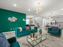 Open concept living room with modern decor, a striking green wall, and seamless flow to the dining and kitchen areas at 1999 Tropical Palms Cir, Kissimmee, FL 34747