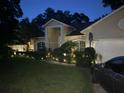 Inviting two-story home featuring manicured landscaping, lawn lighting, and a basketball hoop at 2435 Sweetwater Country Club Place Dr, Apopka, FL 32712