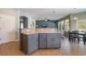 Open-concept kitchen with gray cabinetry, granite countertops, breakfast bar, and an adjacent dining area at 3223 Blazing Star Ln, Harmony, FL 34773
