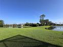 Expansive green backyard featuring a serene lake view, offering a tranquil and picturesque setting at 3225 Regal Crest Dr, Longwood, FL 32779