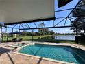 Inviting screened-in pool and jacuzzi with scenic lake views, perfect for outdoor relaxation and entertainment at 3225 Regal Crest Dr, Longwood, FL 32779