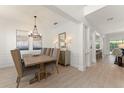 Formal dining room with modern chandelier, wood table, and elegant decor at 390 Anessa Rose Loop, Ocoee, FL 34761
