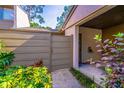 Close-up of the townhome's entry area with a privacy fence, tropical plants, and a covered entryway at 458 Meadowood Blvd, Fern Park, FL 32730