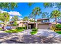 Attractive townhomes displaying well-manicured lawns, covered carports, and mature trees under a sunny sky at 458 Meadowood Blvd, Fern Park, FL 32730