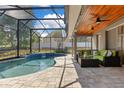 A lovely covered patio with a pool and screened enclosure provides the ultimate outdoor living experience at 5335 Bay Side Dr, Orlando, FL 32819