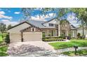 Attractive home featuring stone accents, a three car garage, and manicured landscaping at 5944 Lake Melrose Dr, Orlando, FL 32829