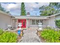 Inviting home entrance featuring a red double door, beautiful brick pathway, and decorative planters at 604 Ponca Trl, Maitland, FL 32751