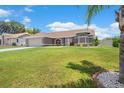Beautiful home with lush green lawn and manicured flowerbeds, surrounded by mature trees at 801 Hunt Dr, Lake Wales, FL 33853