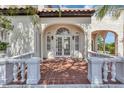 Grand entrance to this stucco home with a red tile porch, and arched entryway and manicured landscaping at 802 S 10Th St, Haines City, FL 33844