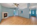 Spacious room with a fireplace, wood floors, a ceiling fan, and an exterior door at 925 S Dean Cir, Deltona, FL 32738