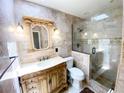 Elegant bathroom featuring marble walls, a glass-enclosed shower, and an ornate vanity with stylish lighting fixtures at 5723 Harcourt Ave, Orlando, FL 32810