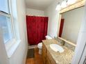 Well-lit bathroom featuring a granite countertop vanity, tiled floors, and a shower with a decorative curtain at 5723 Harcourt Ave, Orlando, FL 32810