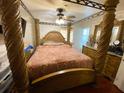 Bedroom features a four poster bed with ornate details and matching dresser at 5723 Harcourt Ave, Orlando, FL 32810