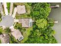 Aerial view of a waterfront home, complete with a private dock, serene lake, and lush greenery at 1203 Stone Harbour Rd, Winter Springs, FL 32708