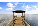 Waterfront dock with covered area, perfect for relaxing and enjoying stunning views of the tranquil lake at 1203 Stone Harbour Rd, Winter Springs, FL 32708