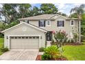 Inviting two-story home featuring a well-manicured lawn, attached garage, and decorative shutters at 1203 Stone Harbour Rd, Winter Springs, FL 32708