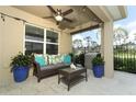 Comfortable covered patio area with a ceiling fan, wicker furniture and plants at 1313 Middle Lake Dr, Ormond Beach, FL 32174