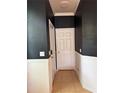 Entry hall with dark-painted walls, white trim and door, and neutral-toned tile flooring at 14344 Desert Haven St, Windermere, FL 34786
