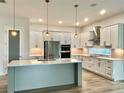 Modern kitchen with white cabinetry, stainless steel appliances, and a central island at 148 Hampton Loop, Davenport, FL 33837