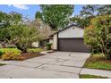 Inviting single-story home with a manicured lawn, mature trees, and a spacious two-car garage at 1508 Southwind Ct, Casselberry, FL 32707