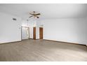 Spacious living room featuring wood floors, a ceiling fan, a front door, and two storage closets at 1508 Southwind Ct, Casselberry, FL 32707
