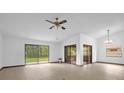 Bright living room featuring sleek wood floors, a ceiling fan, sliding glass doors, and ample natural light at 1508 Southwind Ct, Casselberry, FL 32707